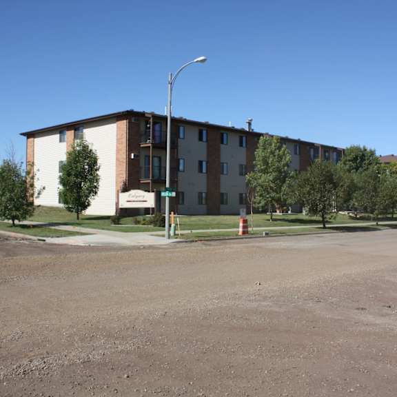 apartment complex with a parking lot in front.