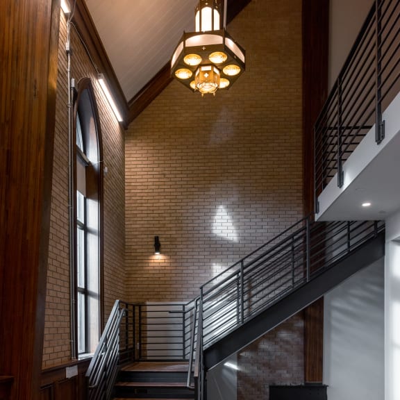 a staircase in a building with a brick wall and wood floors