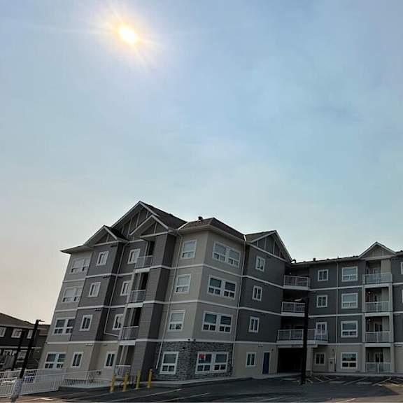 an apartment building with the sun shining over it