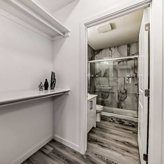 a white bathroom with a long counter and a glass shower