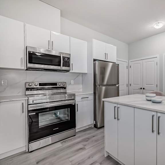 a kitchen with white cabinets and stainless steel appliances
