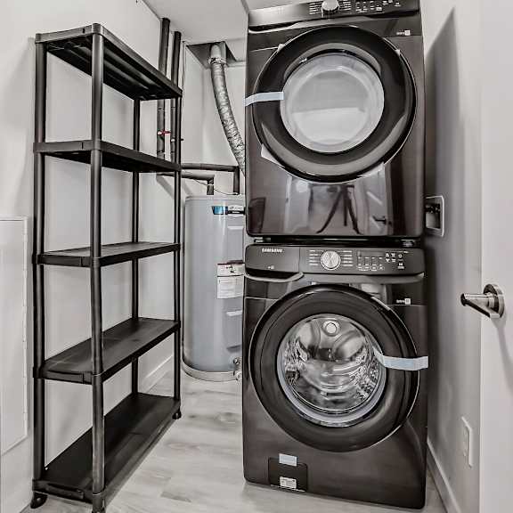 a small laundry room with a washing machine and a shelf