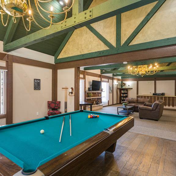 a pool table in a room with a chandelier.