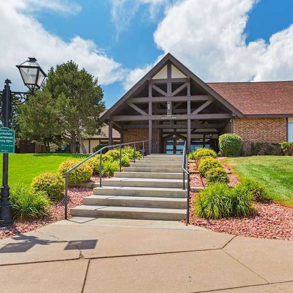a building with a red brick chimney and a green sign in front of it.