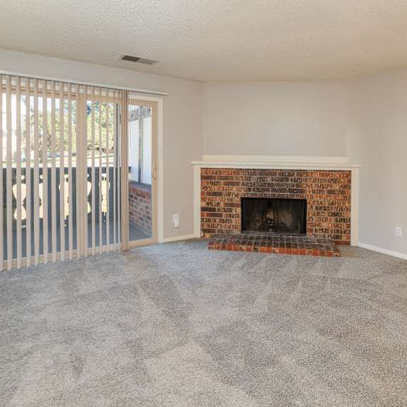a room with a fireplace and a sliding glass door.