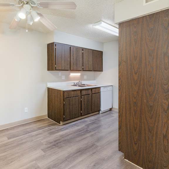 a kitchen with wooden cabinets and a ceiling fan.