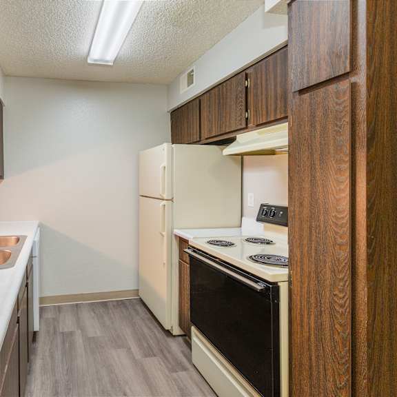 a kitchen with a sink, stove, and oven.