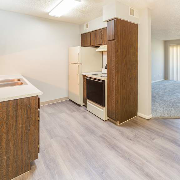 a kitchen with a refrigerator, oven, and cabinets.