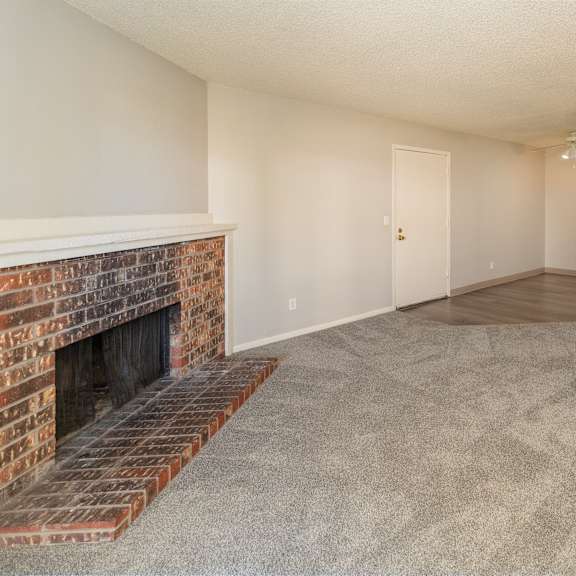 a room with a fireplace and carpeted floor.