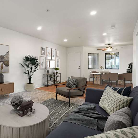a living room with a grey couch, a coffee table, and a painting on the wall.