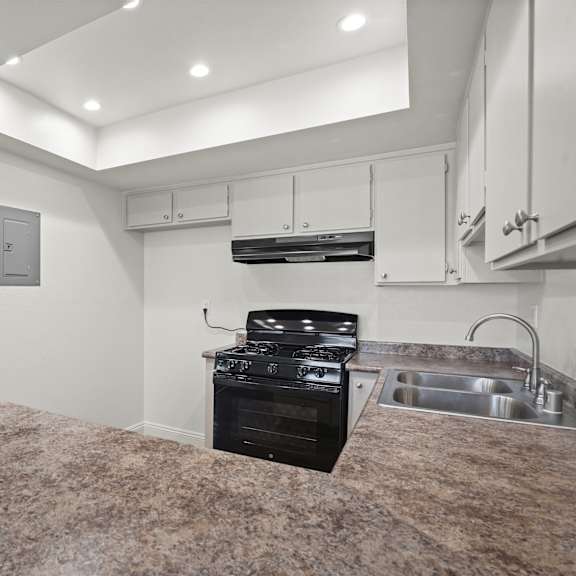 a kitchen with a granite countertop and a stove top oven.
