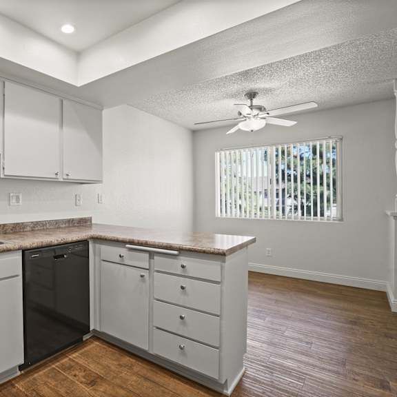 a kitchen with a black stove top oven and white cabinets.