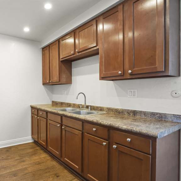 a kitchen with wooden cabinets and a granite countertop.