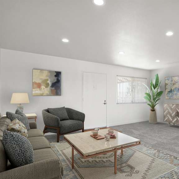 a living room with a grey couch, a brown armchair, a wooden coffee table, and a rug.