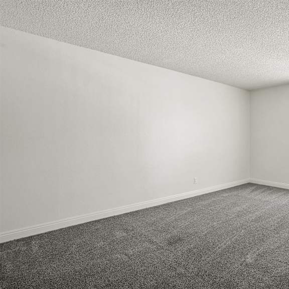 a room with a carpeted floor and a window with blinds.