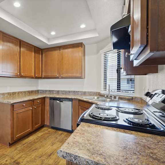a kitchen with wooden cabinets and a granite countertop.