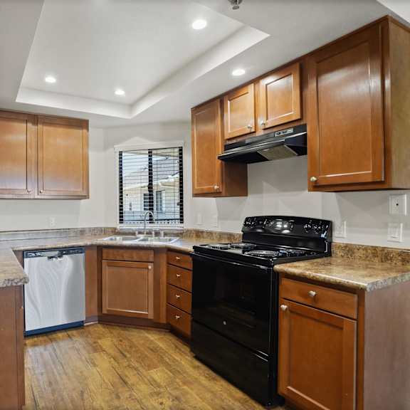 a kitchen with wooden cabinets and a black stove top oven.