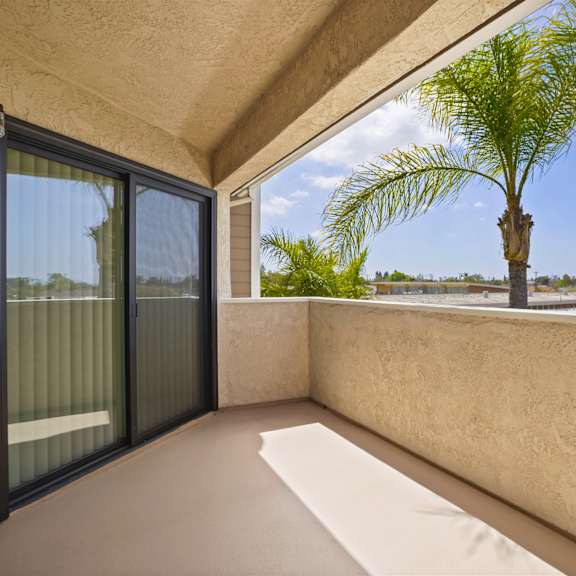 a balcony with a palm tree in the distance.