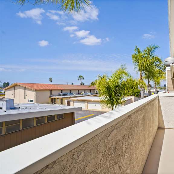 a balcony with a white door and a wall on one side.
