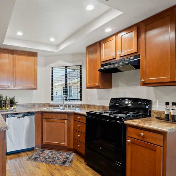 a kitchen with wooden cabinets and a black stove top oven.