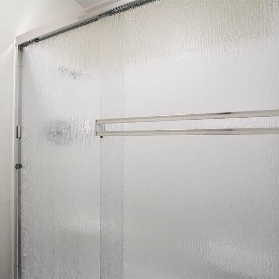 a white refrigerator with a glass door is in a room.