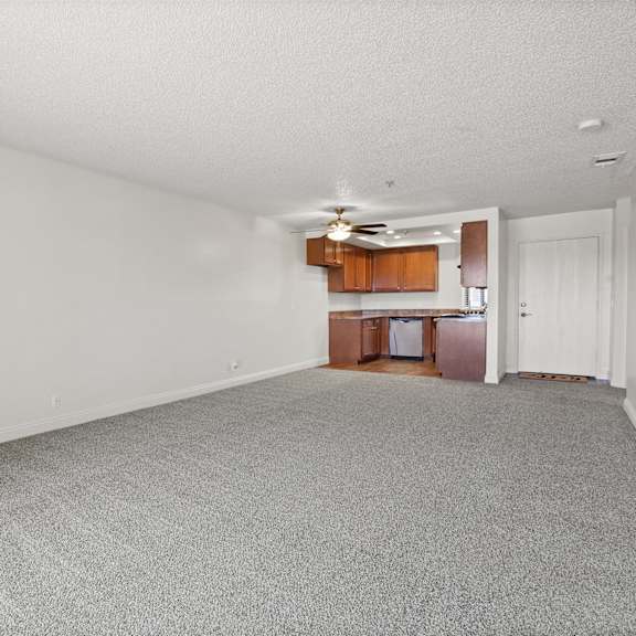 a room with a carpeted floor and a ceiling fan.