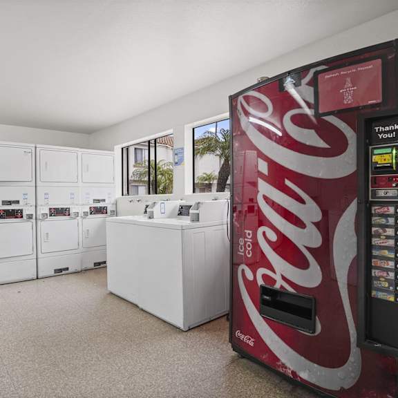 a coca-cola vending machine is in a room with white cabinets.