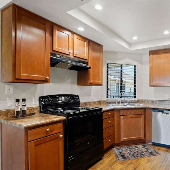 a kitchen with wooden cabinets and a black stove top oven.
