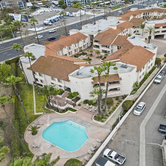 a swimming pool is surrounded by a building with a red tile roof.