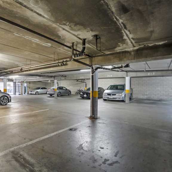 a parking garage with a white car parked in the foreground.
