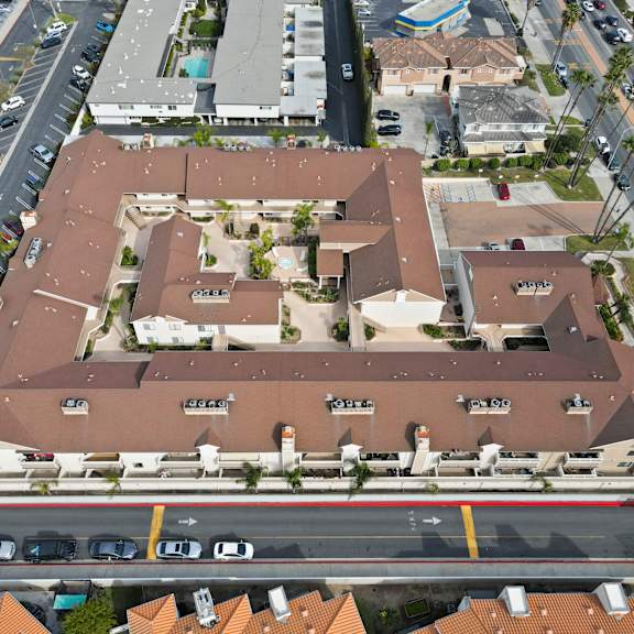 an aerial view of a large building with a parking lot in front.
