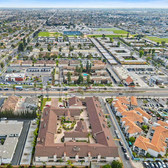 a bird's eye view of a city with buildings, roads, and vehicles.