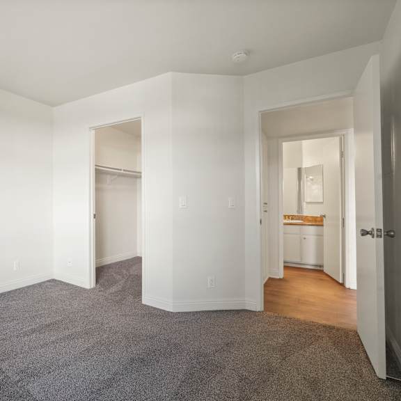 a spacious room with a carpeted floor and white walls.