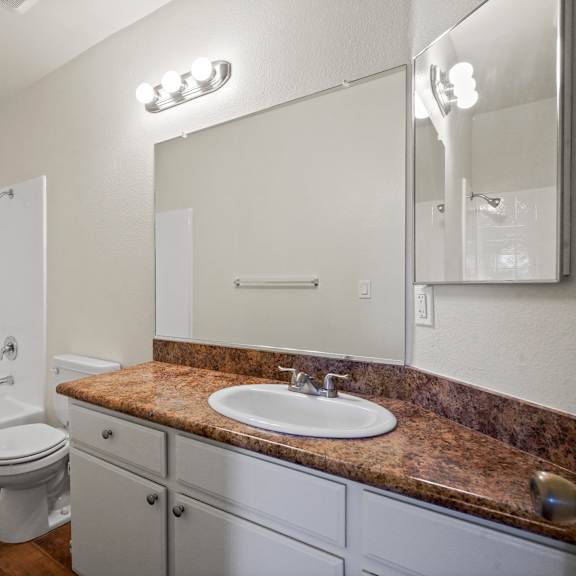 a bathroom with a sink, toilet, and bathtub.