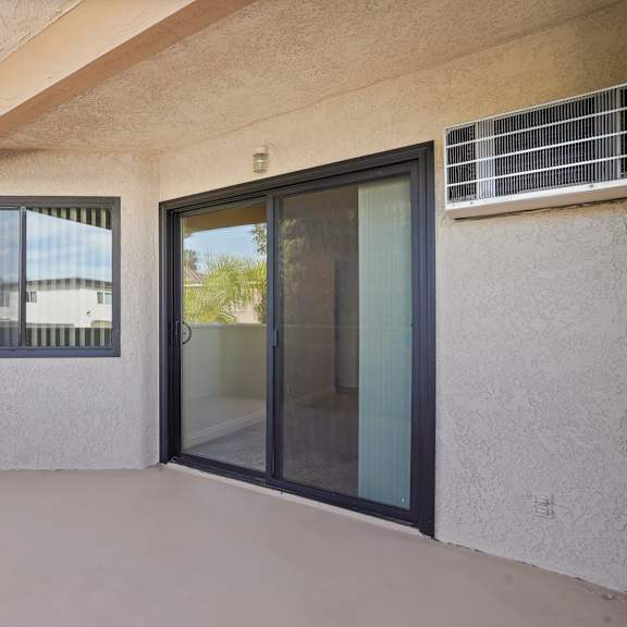 a patio area with a sliding glass door and a window.