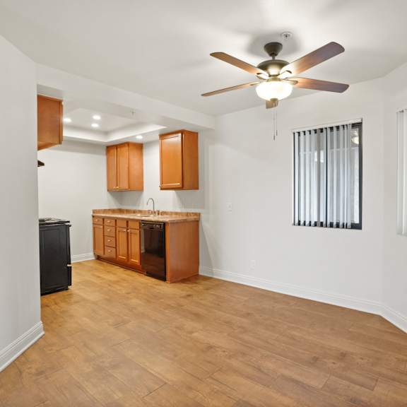 a room with a ceiling fan and wooden flooring.