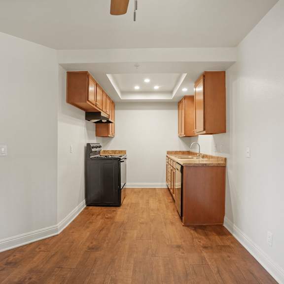 a kitchen area with wooden floors and white walls.