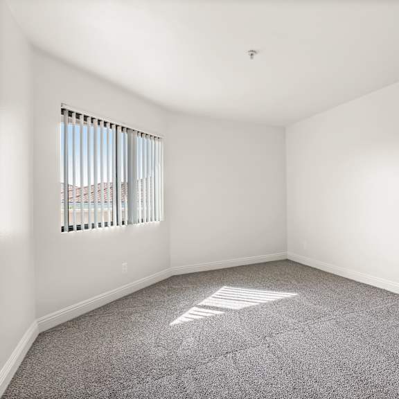 a room with a window and a carpeted floor.