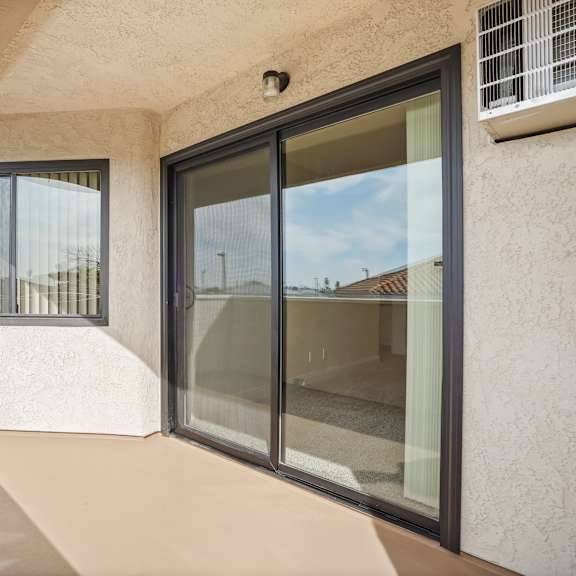 a balcony with a glass door and window.