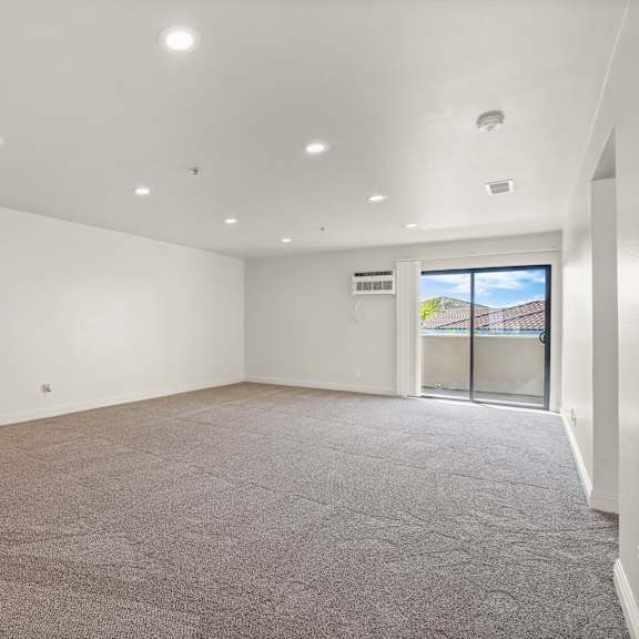 empty room with carpeted floor and sliding glass door.