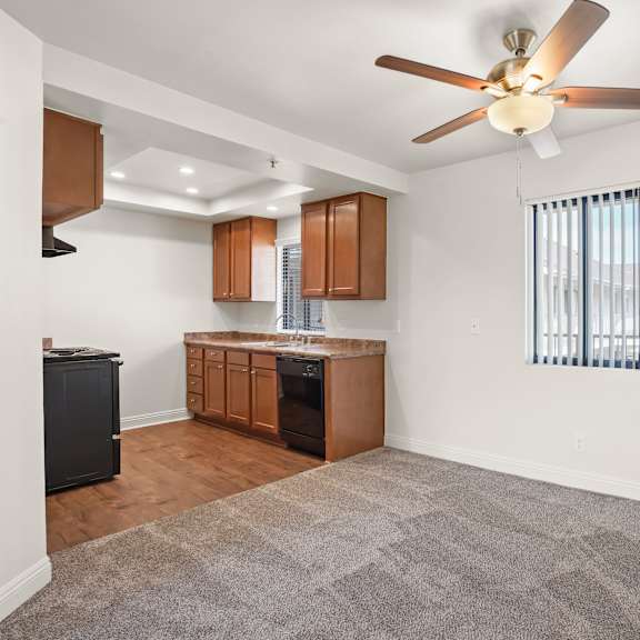 a kitchen with a fan and a window with blinds.