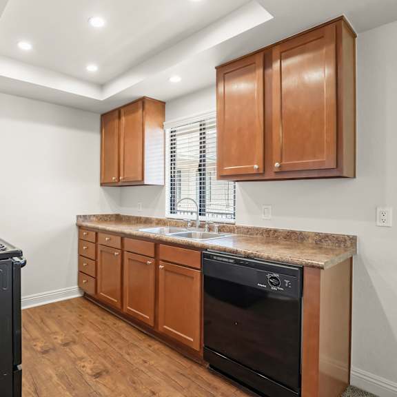 a kitchen with a black stove top oven and wooden cabinets.