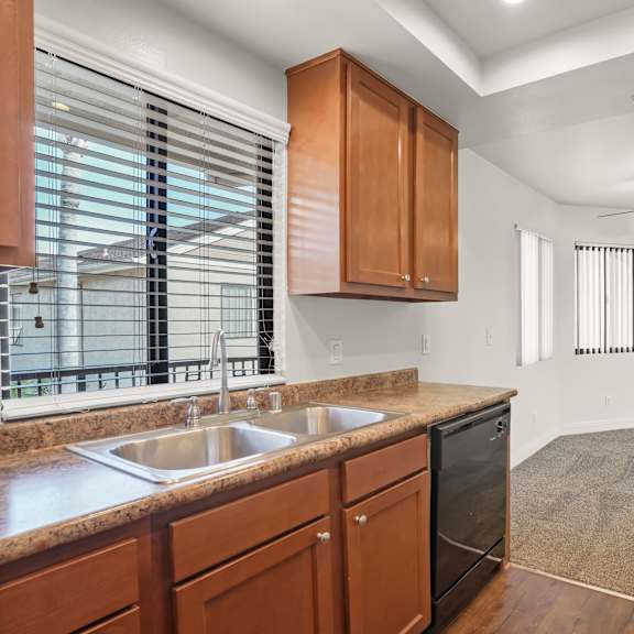 a kitchen with wooden cabinets and a stainless steel sink.