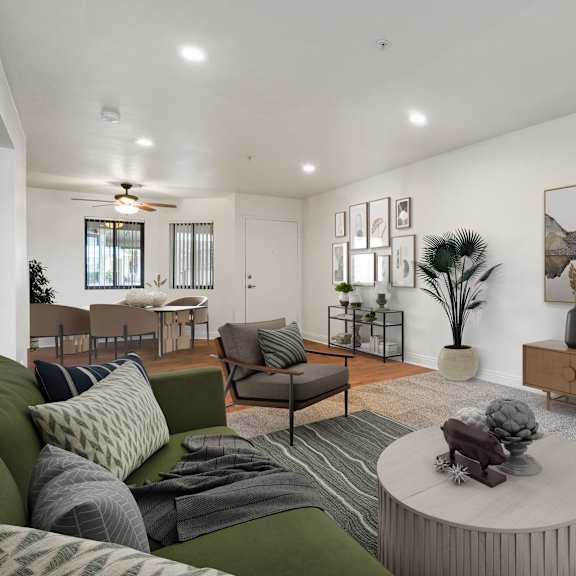 a living room with a green couch, a coffee table, and a painting on the wall.