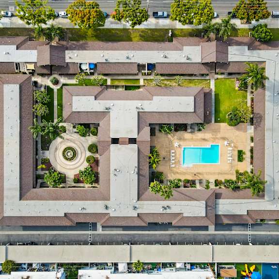 a large complex with a pool and a circular garden in the middle.