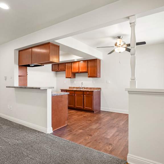 a room with a ceiling fan and wooden floors.