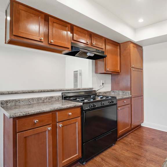 a kitchen with wooden cabinets and a black stove top oven.