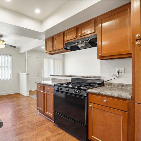 a kitchen with wooden cabinets and a black stove top oven.