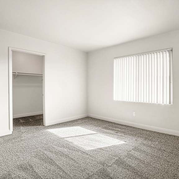 a room with a carpet, a window with blinds, and a door.