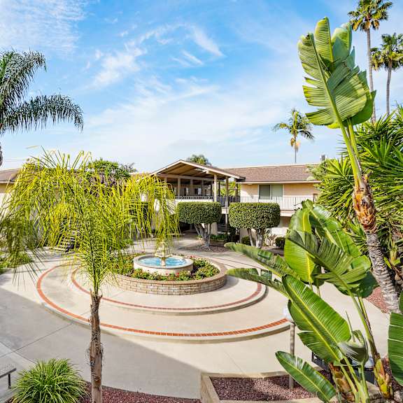 a beautifully landscaped garden with a fountain at its center.